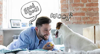 A man smiling at his dog, with speech bubbles saying "good DOG!" and "woof".