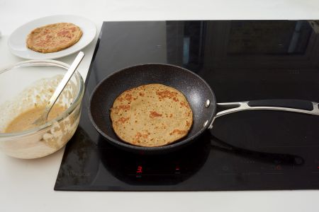 Pancake batter cooking in a pan.