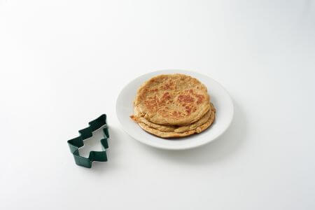 Bowl of cooked pancakes with tree stencil.