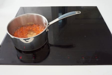 Vegetables cooking on hob.